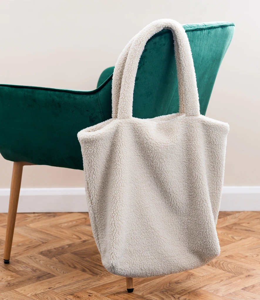 Cream borg fleece tote bag handing off back of chair