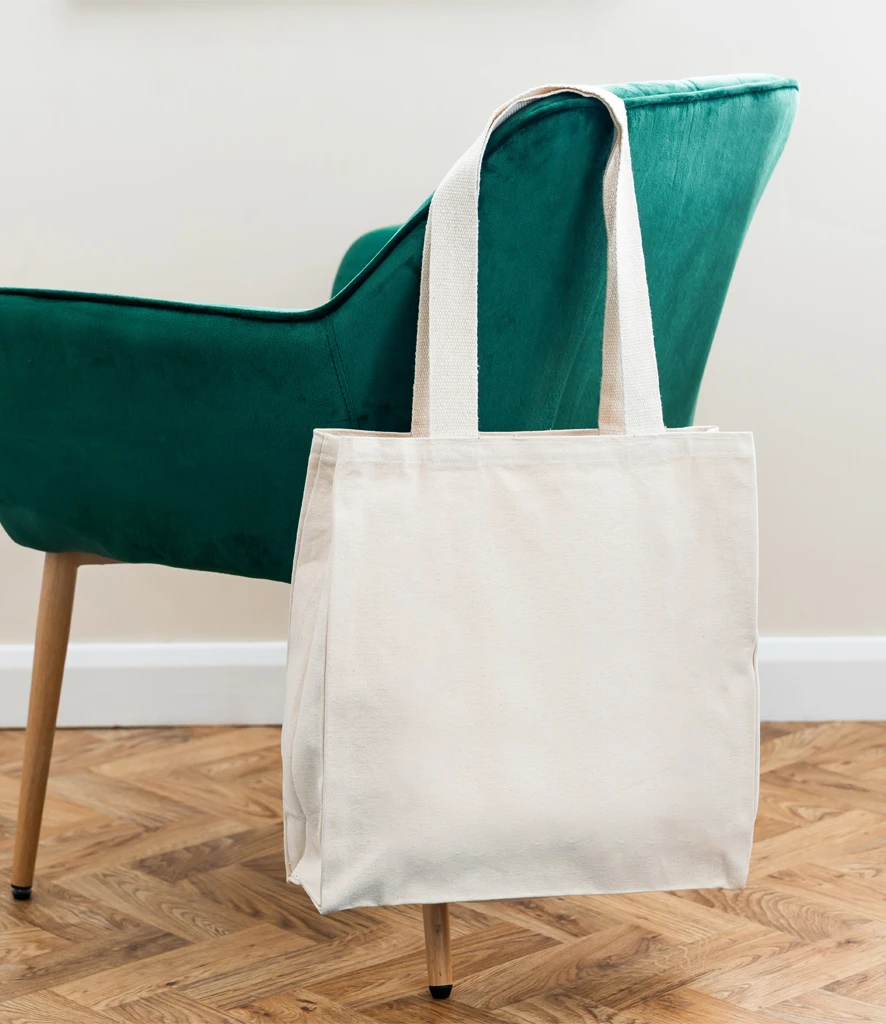 Brand Lab canvas wrap tote bag hanging off green chair 