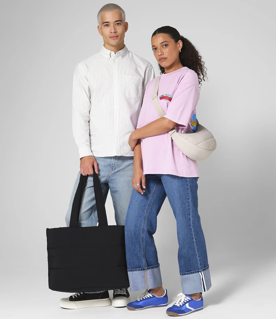 Man and women holding quilted tote bag and over the shoulder bag