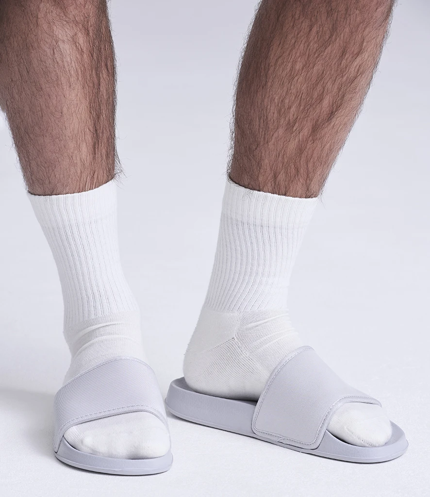 Man wearing white sliders with socks